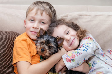 Boy and girl hugging puppy