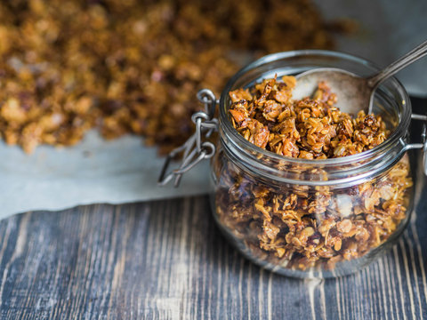 Open glass jar with homemade granola 
