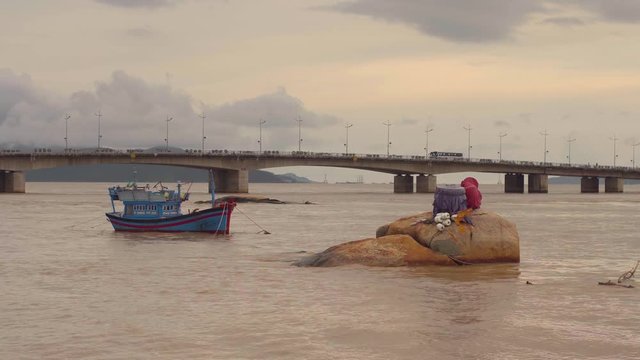 Vietnamese boat on a river at sunset. Little rock in water. Nha Trang, Vietnam travel landscape and destinations.