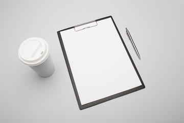 Blank clipboard with coffee on gray background