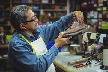 Shoemaker examining a shoe