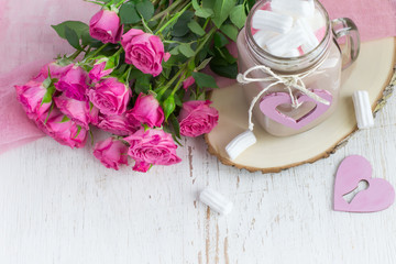 Cocoa with marshmallows and a bouquet of roses.