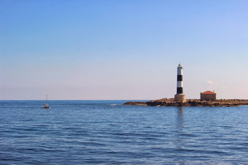 Small lighthouse and a sailboat on Formentera, Ibiza, Balearic I