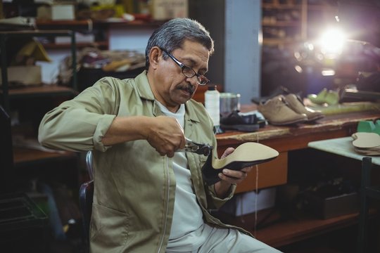 Shoemaker repairing a high heel - Powered by Adobe