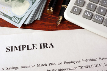 Papers with simple ira and book on a table.