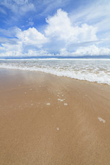 Fototapeta na wymiar Waves sand beach and clouds sunny day