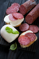 Close-up of bruschettas with smoked sausages and cheese