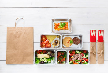 Healthy food take away in boxes, top view at wood