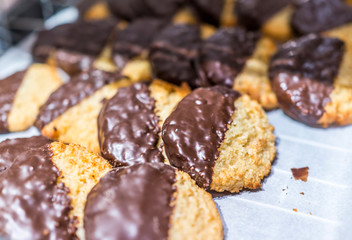 Display of coconut macaroons semi dipped in chocolate glaze on t