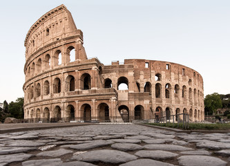 Fototapeta premium Rzymskie Koloseum z rzymską drogą z przodu w ciągu dnia w pełnym widoku