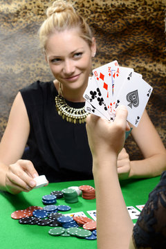 Frau spielt Karten oder Poker mit Freundin als Kartenspiel um Geld
