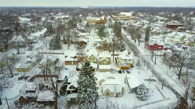 Small town America neighborhood under first snowfall, beautiful traditional homes.

