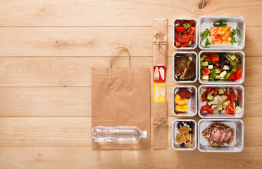 Healthy food take away in boxes, top view at wood