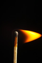 burning match on black background flame wood stick macro