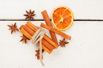 Fototapeta na wymiar Cinnamon and anise on white wooden background. View from above