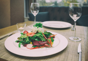Vegetable salad on restaurant table, toned