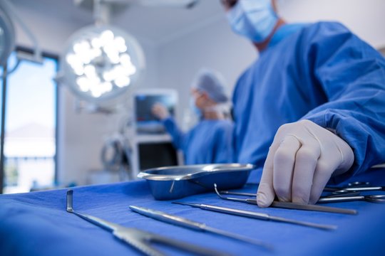Surgeon holding surgical tool in operation theater