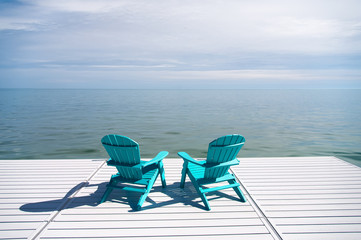 Adirondack or Muskoka Chairs on the dock overlooking the water at the cottage