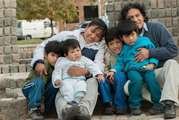 Happy Latin family sitting in the street