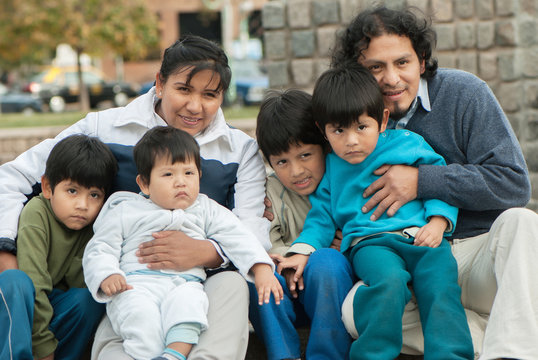 Happy Latin family sitting in the street