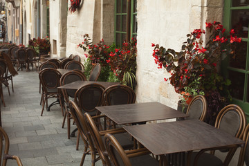 Traditional street cafe concept. Empty tables made of ecological materials