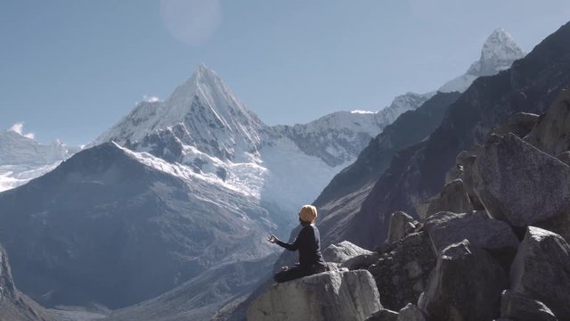 Woman meditating on the top of the park Huascaran and lake paron, Huaraz. Slow motion