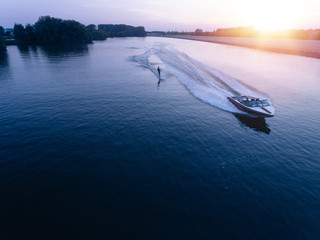 Man water skiiing on lake behind a boat - Powered by Adobe