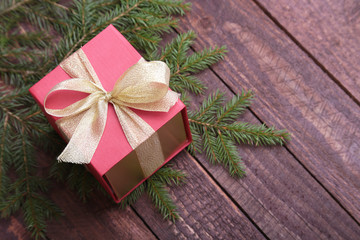 Christmas fir tree with gift box on wooden board
