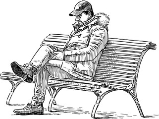 person with a cell phone sits on a park bench