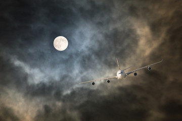 Long-haul night flight through clouds in light of full moon