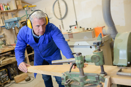 mature carpenter working at a workshop