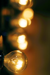 Close-Up Of Lit Light Bulb Against Black Background 