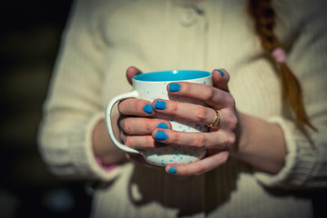 hands holding a drink in a mug, hot drink in hand