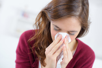 young woman blowing nose