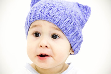 baby boy sitting on table with fruits and vegetables and eating an apple isolated on white background