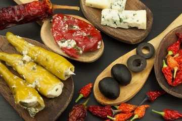 Ingredients for spicy barbecue on the wooden spoon. Dried chillies and spicy peppers filled with cheese. Delicacy suitable for grilled meats. Chillies and cheese. Advertising on spicy delicacies.
