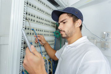 focused electrician applying safety procedure while working on electrical panel