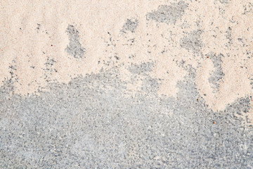 Looks like blurry ice on the pavement surface. On the ice surface is a sand. Slippery walkway. Background.