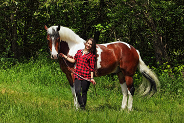 Beautiful and natural young woman spending sometime with her horse