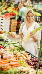 Young woman buying vegetables at the market