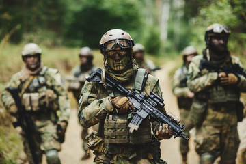 soldiers standing with arms and looks back