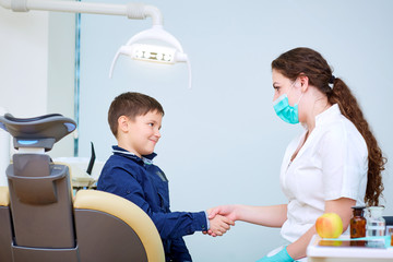 Doctor dentist and child handshake in the office. Dental treatment