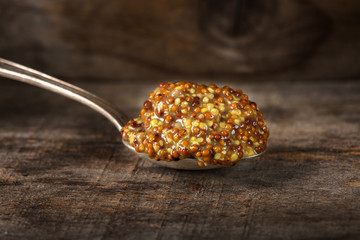 Mustard sauce with seeds and wine in silver spoon