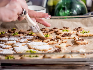 Baking cookies for Christmas. Young woman decorating cookies.