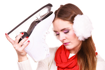 Woman with earmuffs and ice skates.