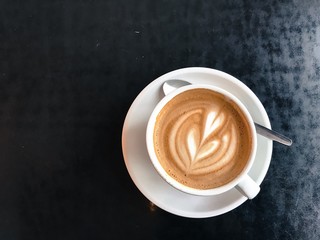 Vintage mood, Cappuccino on top with heart latte art lay on black table