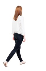 back view of walking  woman in jeans. beautiful blonde girl in m