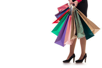 Lower close-up, girl stands holding shopping paper bags and pack