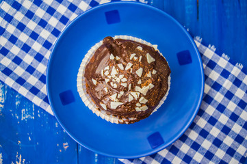 Black Chocolate muffin on a blue wooden background. Top view. Close-up