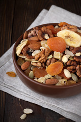 Many dried fruits and nuts mixed in bowl.
